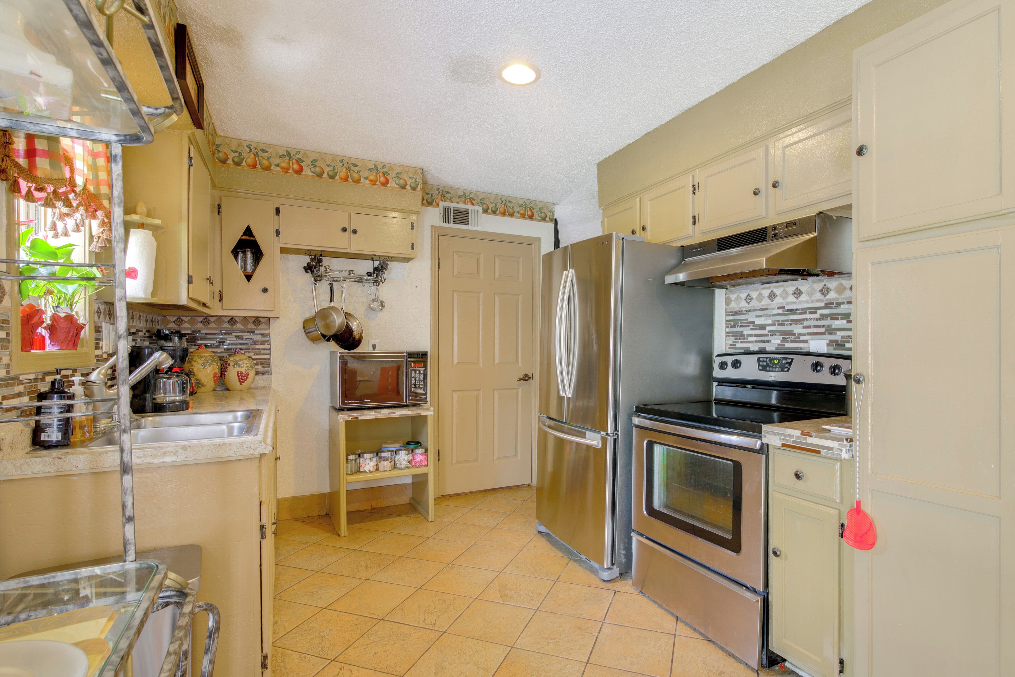 A kitchen with a refrigerator, stove, microwave, and sink.