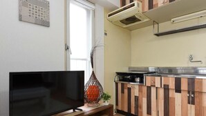 A modern kitchen with wooden cabinets, a built-in oven, and a dishwasher. - Kentaku29 BLD. 72 (Sapporo)