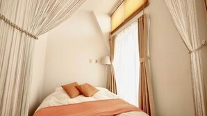 A bedroom with a bed, curtains, a lamp, and a window. - Opus 802 (Sapporo)