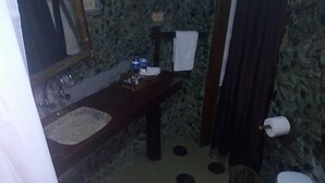 A bathroom with a sink, mirror, towel rack, and toilet.