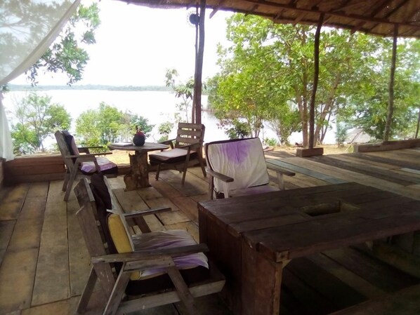 An outdoor wooden deck with a table and chairs, overlooking a body of water. - Elizabeth Village and Resort (Buchanan)