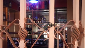 A bar area with shelves stocked with bottles and a decorative metal gate. - Swala Resort (Gilgil)