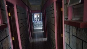 A corridor with patterned floor tiles and pink-painted walls. - Swala Resort (Gilgil)