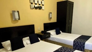 A hotel room with two beds, each with a headboard, bedside tables, and a wall-mounted light fixture. - Hotel Impala de Tampico (Tampico)