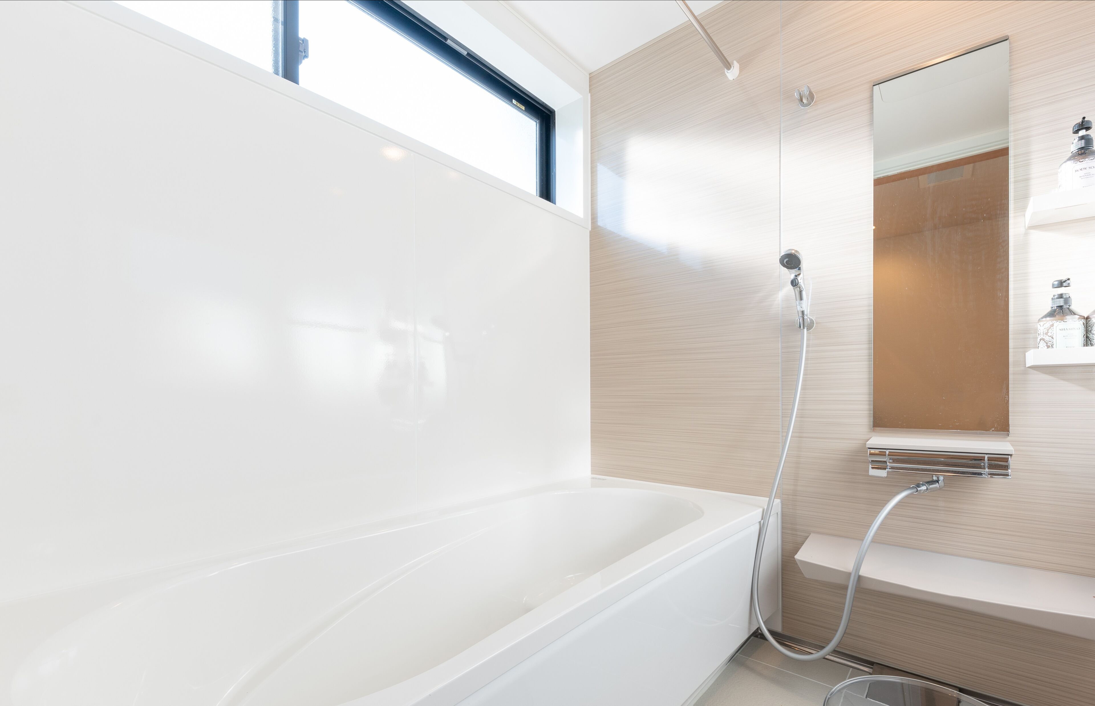 A modern bathroom with a bathtub, a shower, and a large mirror.