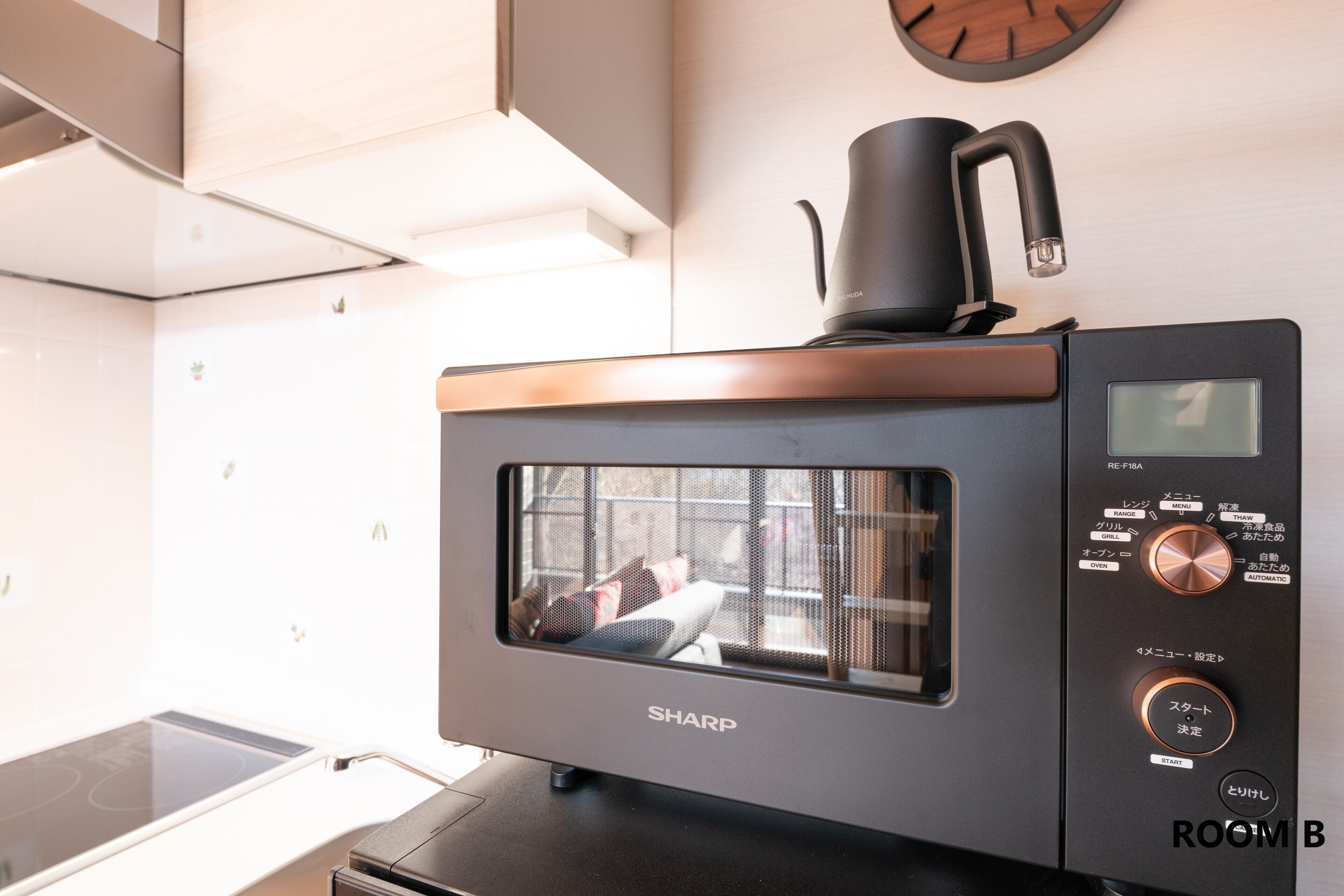 Une cuisine équipée d’un four à micro-ondes, d’une machine à café et d’un panneau de commande numérique.