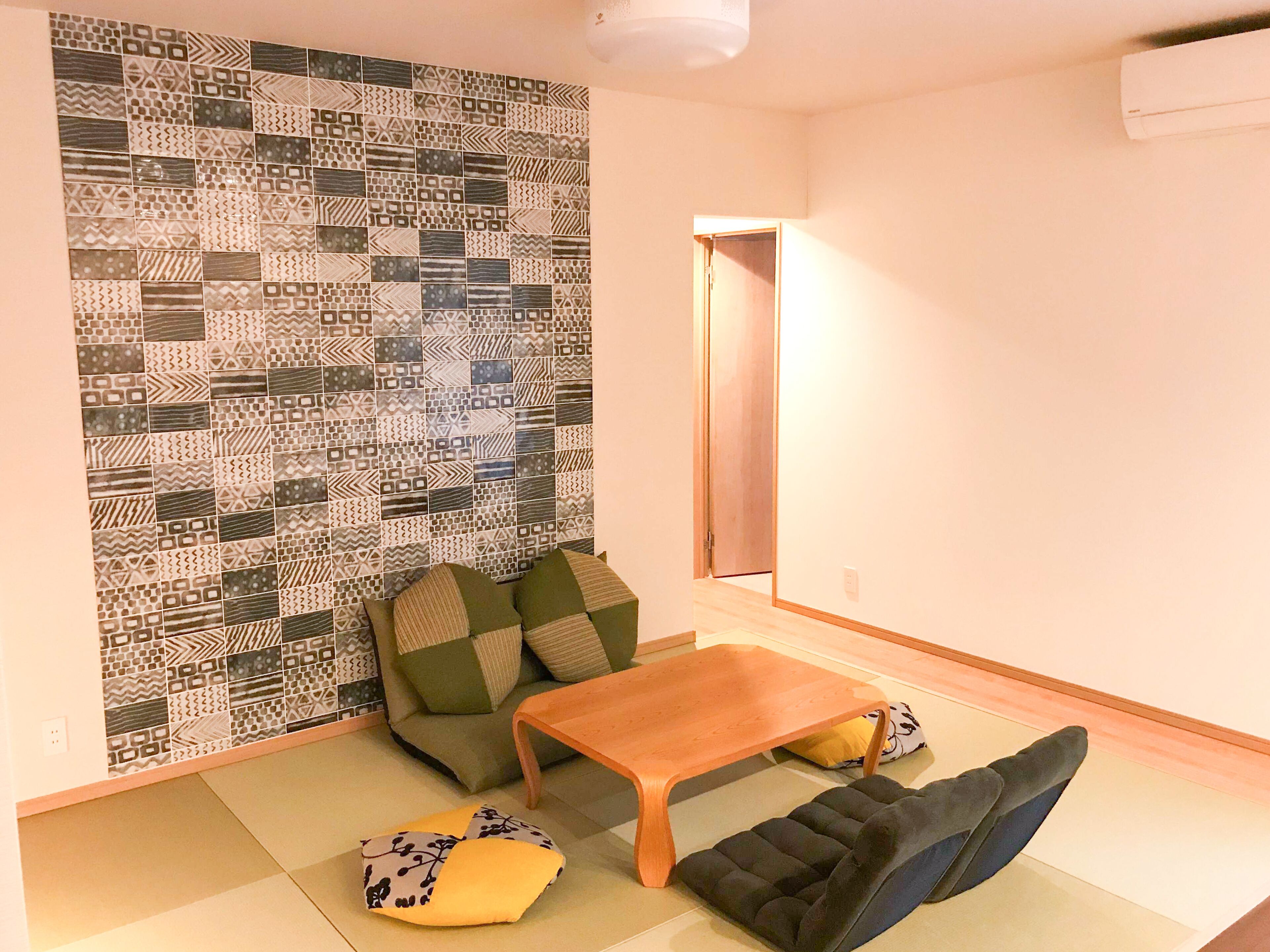 Una sala de estar con una pared estampada, un sofá, una mesa de centro y un futón.