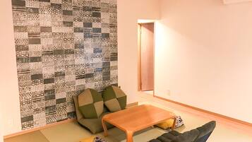 Una sala de estar con una pared estampada, un sofá, una mesa de centro y un futón.