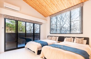 A bedroom with two beds, large windows, and a wooden ceiling. - Villa Hakone Stage (Hakone)
