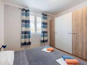 A bedroom with a bed, a wardrobe, and a window with curtains. - Quaint Apartment in Vir near Sea (Vir)