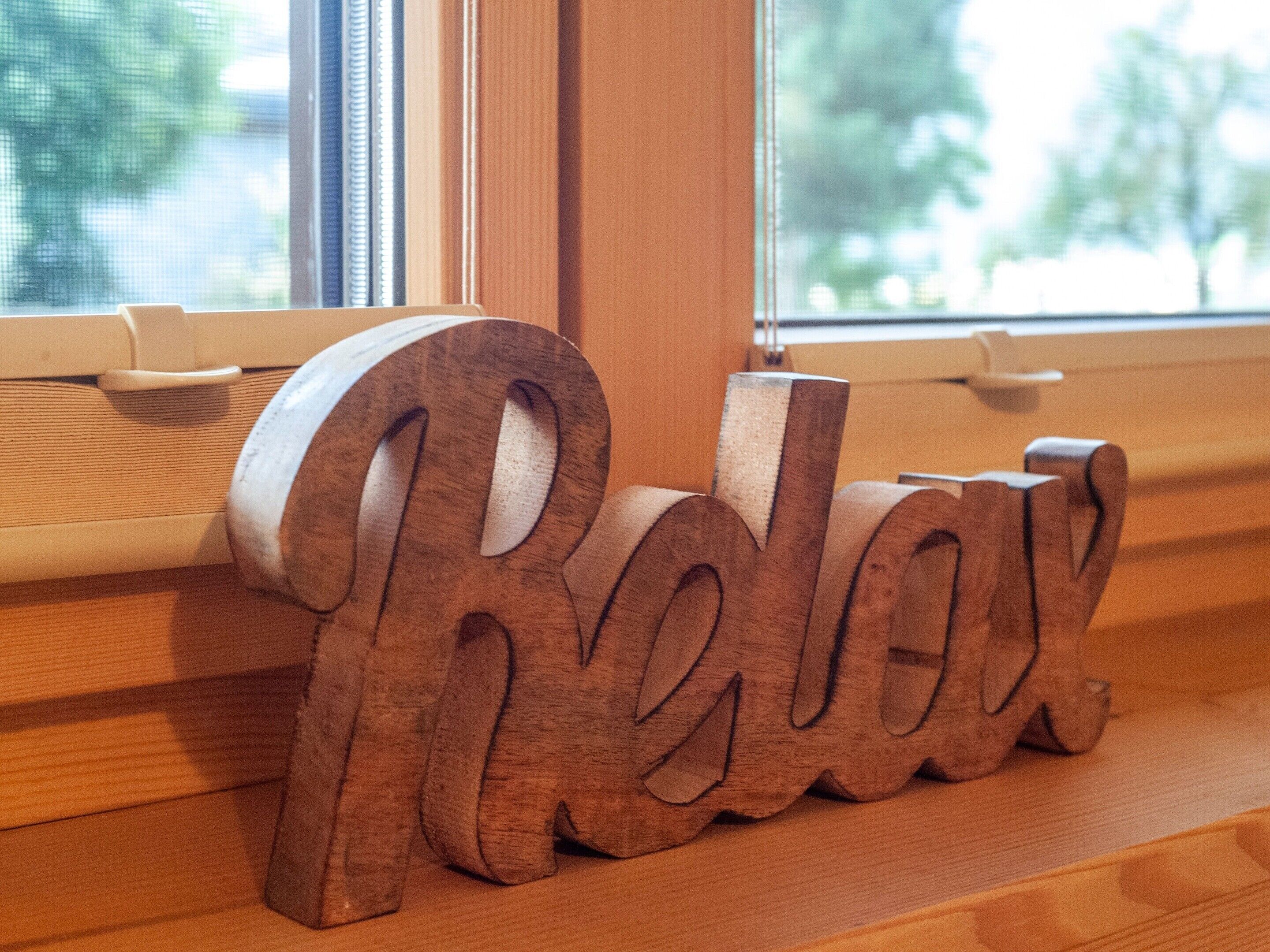 Wooden letters spelling "Relax" on a window sill.