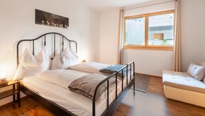 A bedroom with a bed, bedside table, and a window.