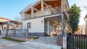 A two-story house with a balcony, a paved entrance, and a fenced yard. - Apartment in Jasenice Near Maslenica Beach (Jasenice)