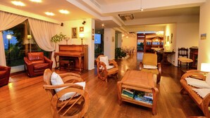 A spacious living room with a piano, wooden furniture, and a view of the outdoors. - Holiday Home in Cropani Marina With Pool (Badolato)
