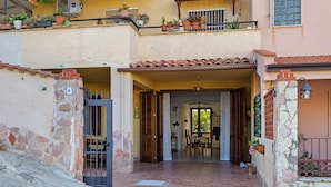 A two-story building with a tiled entrance, stone walls, and a balcony with potted plants. - Cosy Holiday Home in Sanremo With Sea Beach Nearby (Alcamo)