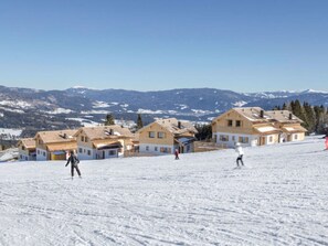 A snow-covered ski slope with wooden buildings and a clear blue sky. - Boutique Apartment in Lungau With Terrace (Weisspriach)