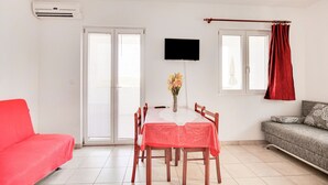A dining area with a table, chairs, a TV, and a sofa. - Tasteful Apartment in Zadar With Balcony (Zadar)