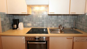 A compact kitchen with a built-in oven, a stovetop, and a sink. - Spacious Apartment in Langenfeld With Sauna (Laengenfeld)