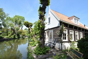 A house with a river in front, a bench, and a tree. - Serene Getaway in Edam (Edam)