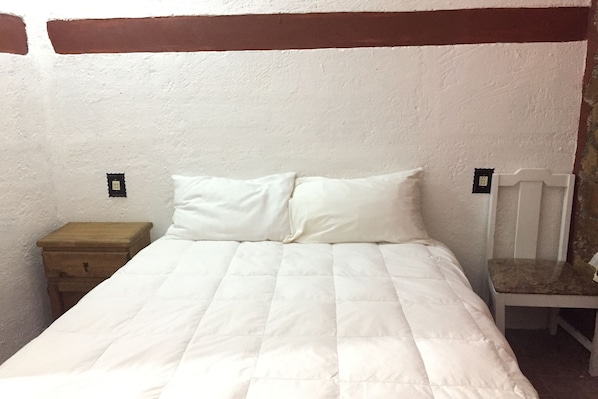 Tabla de planchar con plancha y ropa de cama