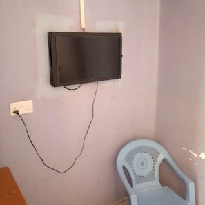 A wall-mounted television with a cable connected to a power outlet.