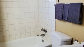 A bathroom with a bathtub, toilet, and sink.
