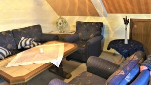 Une pièce confortable avec un canapé, une petite table et une lampe.