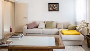 Una sala de estar con sofá, una mesa de centro y un cuadro en la pared.