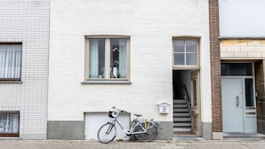 Un edificio blanco con una bicicleta estacionada afuera.
