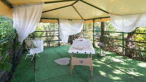A tented outdoor area with a massage table, a small round table, and a chair. - Apartment in Tuoro Near Lago Trasimeno (Tuoro sul Trasimeno)