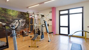 A gym with cardio machines, weightlifting equipment, and a mural of a forest scene. - Apartment in Tuoro Near Lago Trasimeno (Tuoro sul Trasimeno)