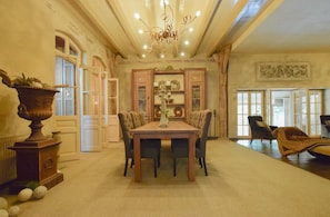 A dining area with a table, chairs, and a chandelier. - Posh Holiday Home in Alphen with Hot Tub (Alphen)