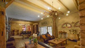 A cozy, rustic interior with wooden furniture, a chandelier, and stone walls. - Posh Holiday Home in Alphen with Hot Tub (Alphen)