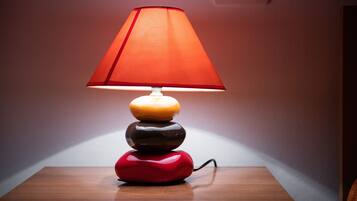 En lampe med rød skærm på en træoverflade.
