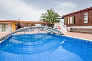 A swimming pool with a clear view of the surrounding buildings and a palm tree.