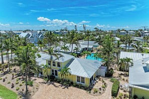 A residential area with houses, palm trees, and a swimming pool.