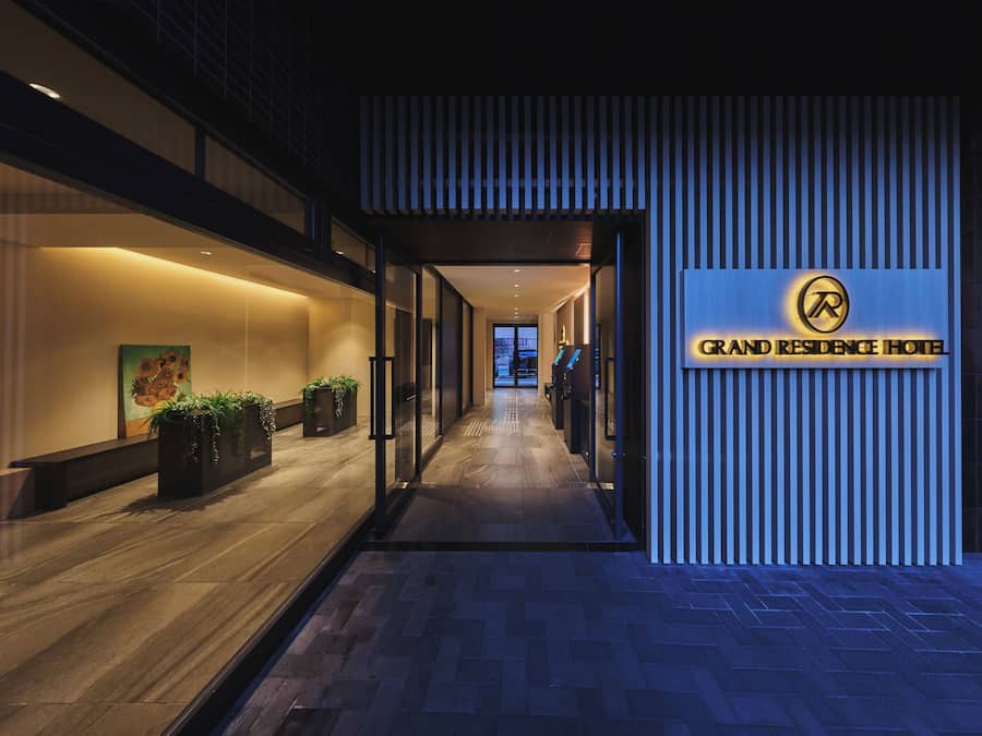 A hotel corridor with a sign for 'Grand Residence Hotel' and a view of the interior.