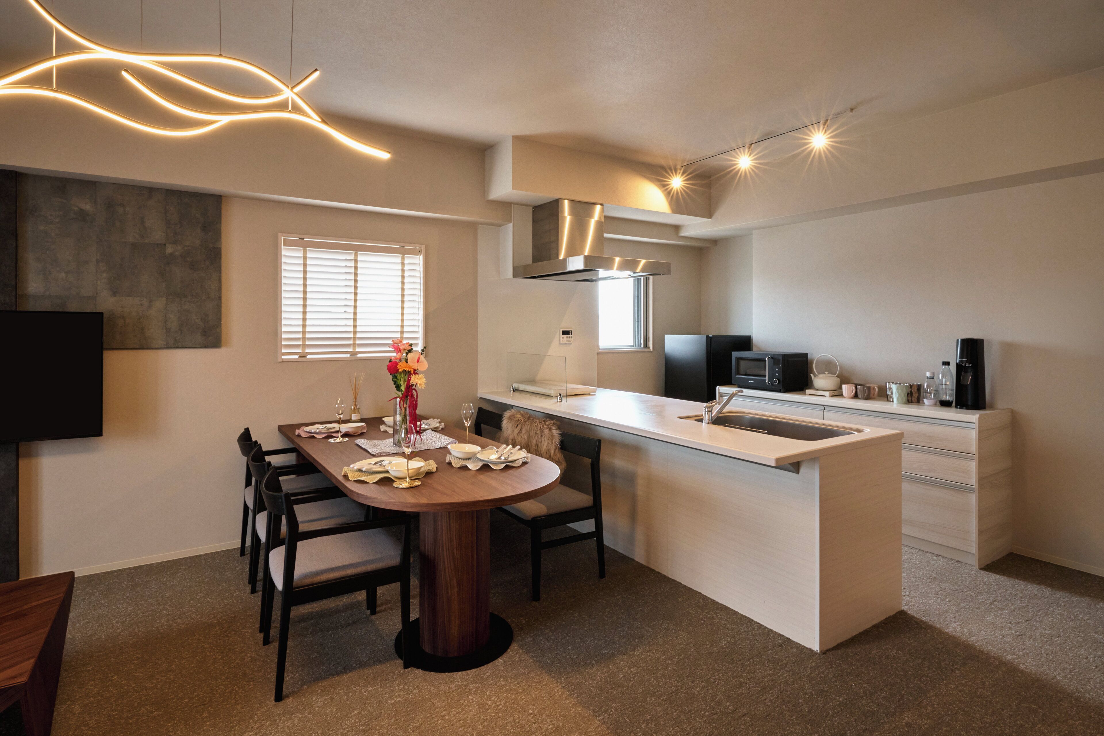 A modern kitchen with a central island, built-in appliances, and a flat-screen TV.