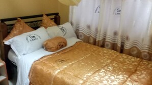 Ein Bett mit einem gemusterten Bettbezug, Kissen und einem Kopfteil.