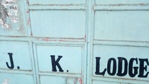 Een muur met de tekst “J. K. LODGE” in het zwart geschilderd.