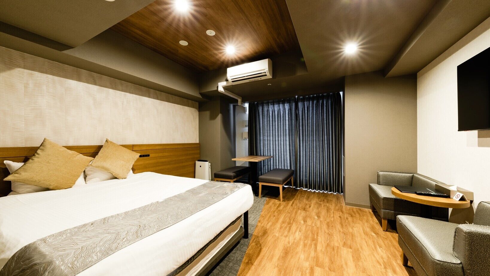 Une chambre d’hôtel avec un grand lit, un bureau, une chaise et un téléviseur.