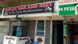 Un immeuble portant une enseigne indiquant « DUPLEX BAR ET RESTAURANT », proposant des boissons et des hébergements.