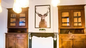 A room with wooden cabinets, a fireplace, and a framed deer head picture. - Holiday Home in Frasnes With Garden (Couvin)