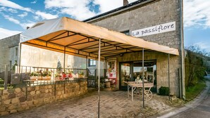 A stone building with a sign reading "La passiflore". - Holiday Home in Frasnes With Garden (Couvin)