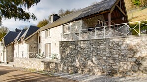 A stone house with a sloped roof and a balcony. - Luxury Pool Villa in Sosoye (Anhée)