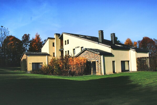 A modern two-story house with a stone facade, multiple chimneys, and a well-maintained lawn. - Holiday Home in Gros Fays With Garden (Bievre)