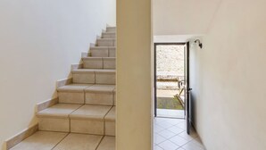 Una escalera que lleva a un espacio exterior con barandilla de metal.