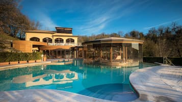 Una piscina al aire libre, una piscina climatizada