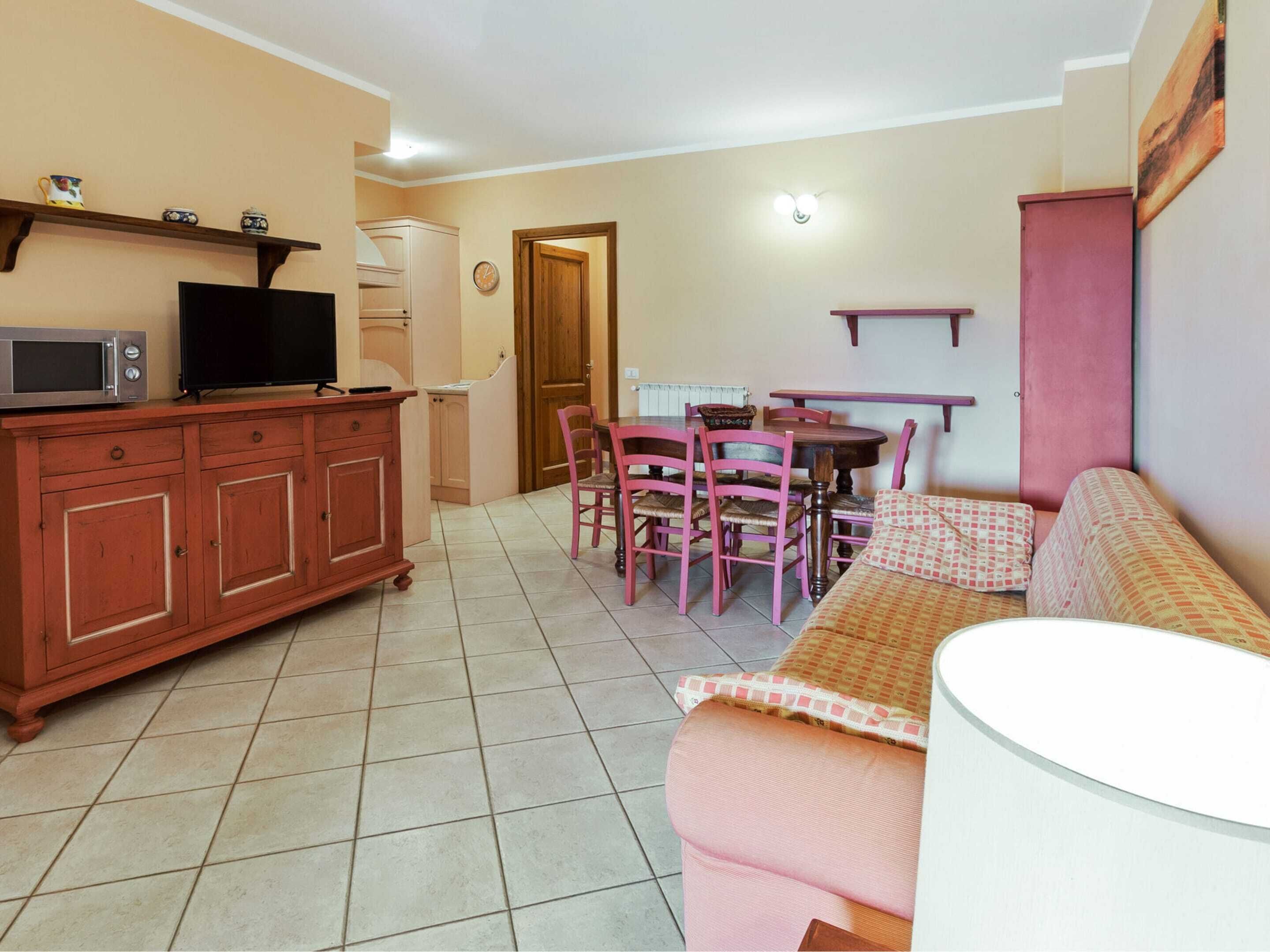 A compact living space with a kitchenette, a dining area, and a sofa.