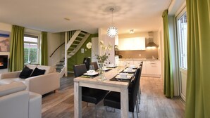 A modern living room with a dining area, a staircase, and a kitchen. - Breskens Haven: Relax, Explore & Dine (Breskens)